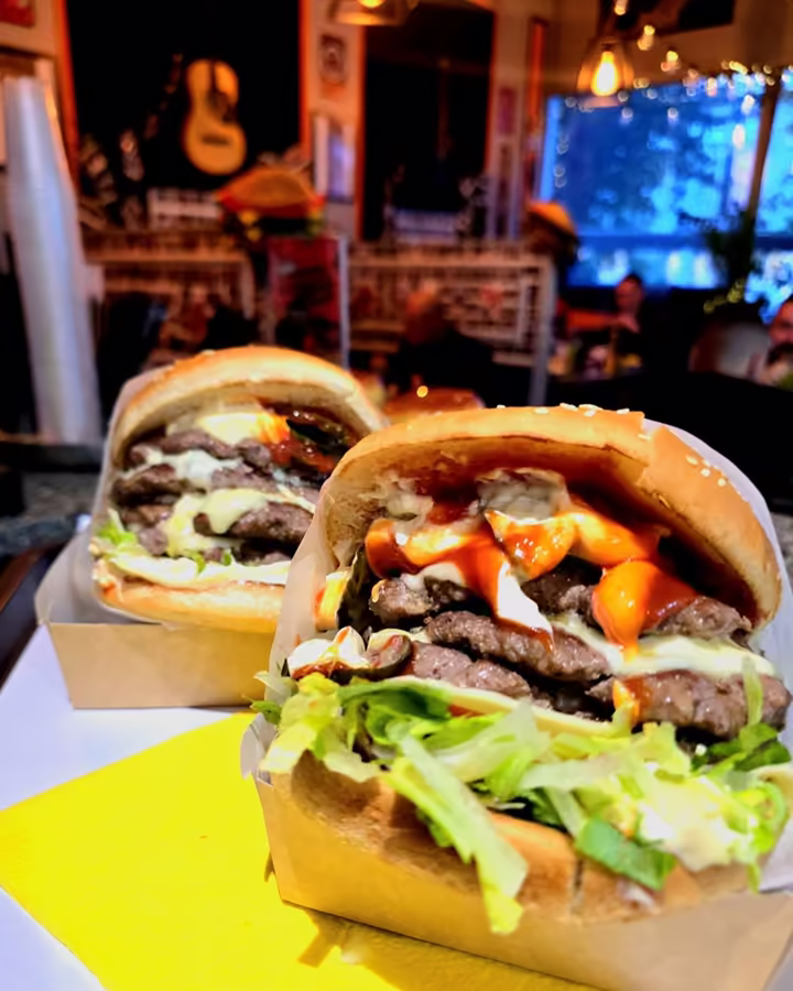 Dwa burgery z frytkami na tacy w lokalu GC's